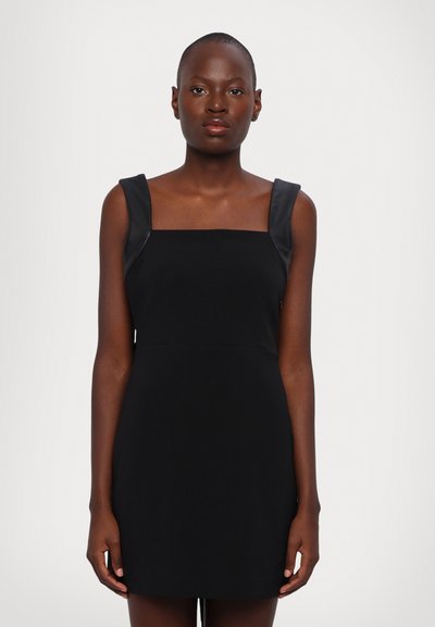 Zwarte jurk met een vierkante halslijn, brede banden en een aansluitende silhouette. Glad materiaal met een matte textuur en een minimalistisch ontwerp.
