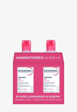 Deux flacons de 500 ml d'eau micellaire Bioderma Sensibio H2O pour peau sensible dans un emballage rose avec un texte promotionnel en allemand.