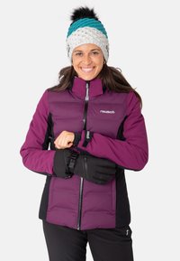 Lila und schwarze, isolierte Winterjacke mit Reißverschluss, kombiniert mit schwarzen Handschuhen und einer gestrickten Mütze mit türkisfarbenen, weißen und schwarzen Akzenten.