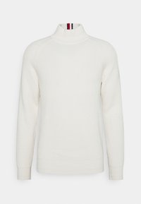 Maglione a collo alto crema con texture a costine, maniche lunghe e accenti a strisce in contrasto sul colletto. Vestibilità classica.