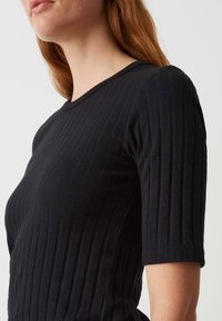 Top corto a maniche corte nero a coste, con tessuto testurizzato e righe verticali, scollatura a girocollo e silhouette aderente.