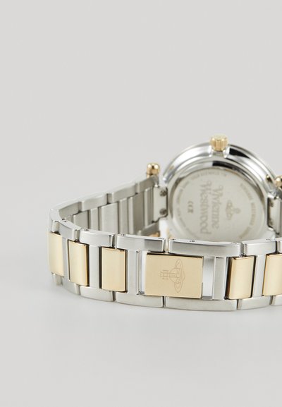 Ρολόι βραχιόλι από μέταλλο σε ασημί και χρυσό χρώμα με στρογγυλή κάσα, διάφανο γυαλί και εγχάρακτο πίσω μέρος; εναλλαγή βουρτσισμένων και γυαλισμένων συνδέσμων.