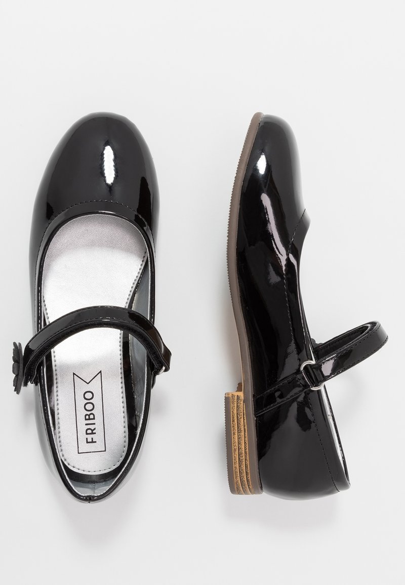 Černé lakované Mary Jane boty s kulatou špičkou, nastavovacími popruhy a texturovanou tan gumovou podrážkou. Stříbrná podšívka a značka.