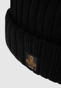 Beanie nero a coste con risvolto, caratterizzato da un'etichetta rettangolare con un logo di cane giallo e il testo "Refugiwear".
