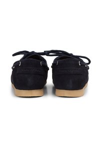 Navy-Suede-Schuhe mit Schnürverschluss, sichtbaren Ösen und einer glatten, hellbraunen Gummisohle. Mit einem Logo auf der Rückseite.