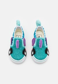 Turkoosi liukujalkineet, joissa on kimaltava pinta, purppuran sävyisiä yksityiskohtia, mustat silmät ja takana pörröinen sininen häntä. Valkoinen kumipohja.