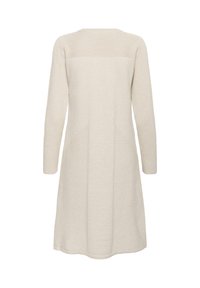 Térdhoszban végződő, krémszínű ruha texturált kötött anyagból, szilárd felső résszel és finom geometriai mintával a testen.