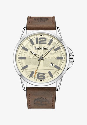 Rjav usnjen pas z uro s srebrnim okvirom, smetanasto belo številčnico, sivimi oznakami ur in oranžno kazalcem za sekunde, vsebuje logotip Timberland.