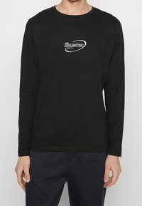 Langärmliges schwarzes T-Shirt aus weicher Baumwolle, mit einem weißen "UNLIMITED" Grafik und rundem Halsausschnitt, in lässiger Passform.