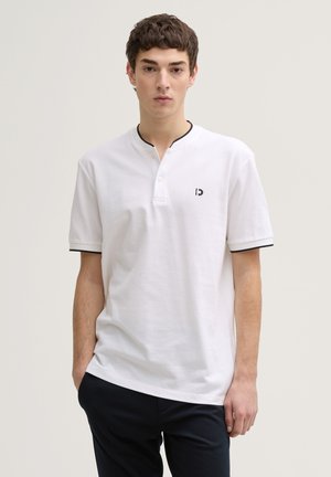 Witte katoenen polo met korte mouwen, zwarte afwerking op de kraag en mouwen, met een klein logo op de linkerkant van de borst.