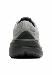 Sivé športové topánky s textúrovaným zvrškom, polstrovaným golierom a hrubou čiernou medzipodrážkou. Výrazné dizajnové akcenty zahŕňajú zúžené bočné panely.