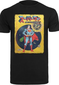 Melna T-kreklu ar krāsainu vintage Supermana grafiku, kurā attēloti zilas un sarkanas kostīmu detaļas uz dzeltena un zila fona.