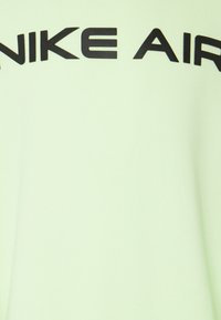 Hellgrüner Sweatshirt mit glatter Textur. Auf der Brust in fetten schwarzen Buchstaben steht "NIKE AIR". Einfaches Design, Pullover-Stil.