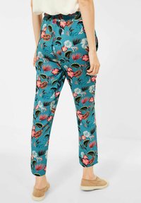 Blumige Hosen aus teal-farbenem Stoff mit rosa und grünen Mustern, slim fit mit elastischem Bund und leicht verjüngendem Beinabschluss.
