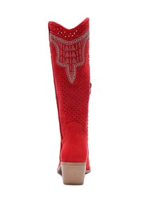 Bota alta de ante roja con detalles recortados, acentos metálicos en la parte superior y un tacón de madera apilada.
