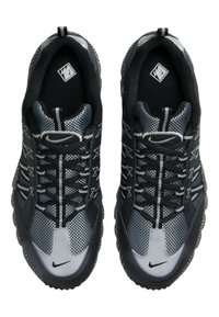 Zwarte en grijze Nike sneakers met een mesh bovenwerk, textuur overlays en contrasterende stikpatronen, met een ronde neus en een stevige zool.