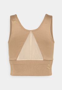 Brassière de sport beige avec larges bretelles, panneau avant en mesh en forme de V et petits logos Puma dorés sur l’épaule gauche et la bande inférieure.