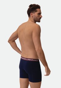 Granatowe bokserki z bordowym elastycznym paskiem w pasie z napisem „ENDURANCE”, wykonane z gładkiej, rozciągliwej tkaniny.