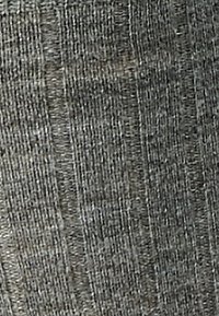 Primo piano di un tessuto grigio testurizzato con un motivo intrecciato che presenta linee verticali e orizzontali intersecate.