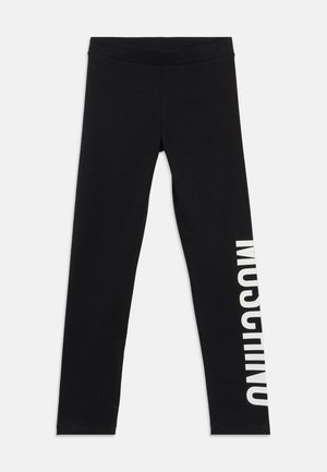 Leggings noirs en tissu extensible, avec une taille haute et la mention « MOSCOW » imprimée en grandes lettres blanches le long du côté gauche.