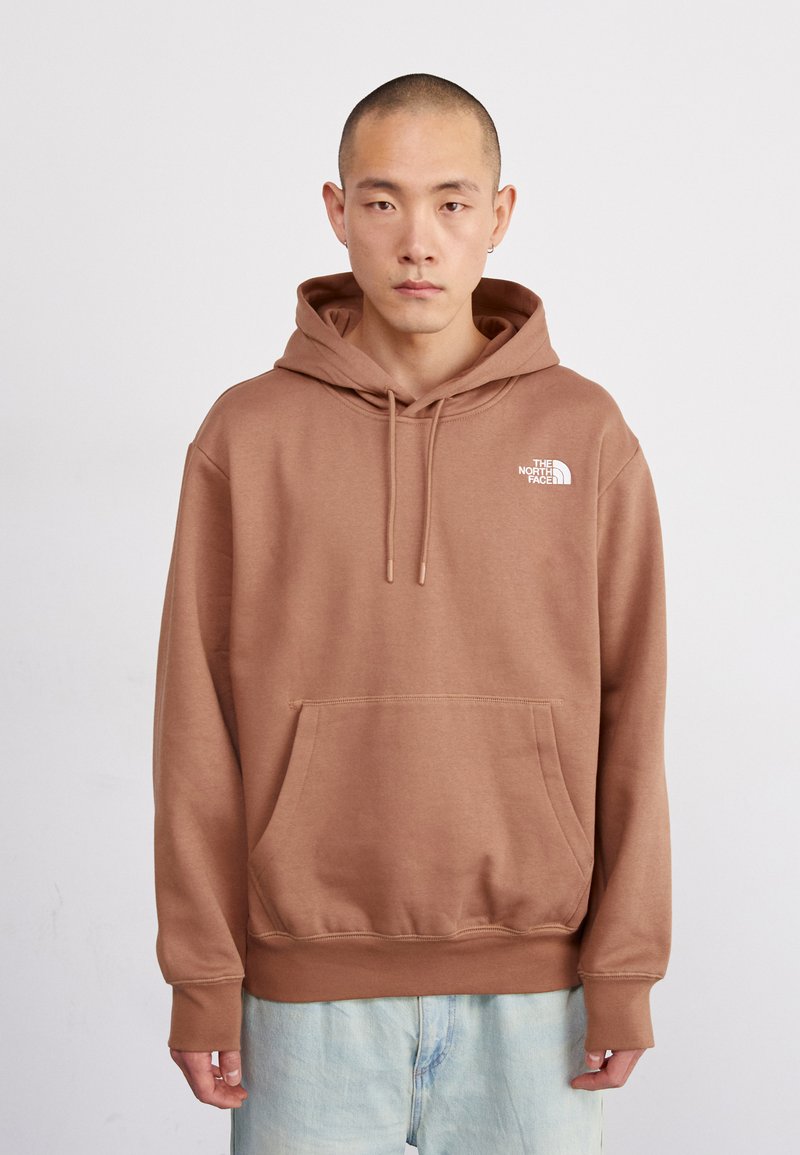 Sudadera de algodón marrón con un bolsillo delantero y capucha ajustable con cordón. Presenta un logo blanco en el lado izquierdo del pecho y puños acanalados.