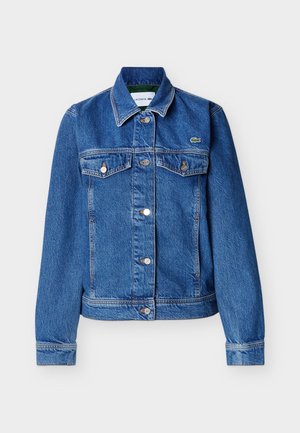 Veste en denim bleu avec fermeture à boutons, deux poches à rabat sur la poitrine, manches longues et un petit logo de crocodile vert sur le côté gauche de la poitrine.