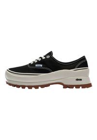 Schwarze Leinensneaker mit weißen Schnürsenkeln, gummierter Zwischensohle und braunem strukturiertem Außensohlenmaterial. Verfügt über kontrastierende weiße Nähte und ein Logo-Tag.