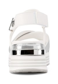 Sandalo bianco con cinturino regolabile e accenti metallici argento. Presenta una fascia texturizzata e un design di suola spessa e stratificata.