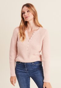 Hellrosa gestrickter Pullover mit V-Ausschnitt, der ein strukturiertes Muster und fünf Knöpfe vorne hat. Lange Ärmel mit gerippten Bündchen.