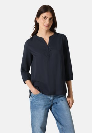 Marineblauwe blouse met een V-hals, driekwartmouwen en knoopdetail. Gemaakt van lichte stof, met een ontspannen pasvorm en een afgeronde zoom.