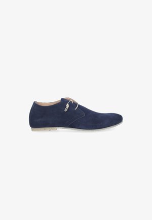 Navy blue suede men's derby shoe with beige laces and light beige sole shown in side view on white background.