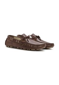 Mocasines de cuero marrón con un detalle de flecos en la puntera, cordones redondos y suelas de goma con pequeñas ranuras para tracción.