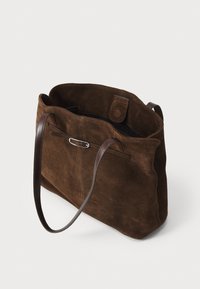 Borsa tote in suede marrone con una forma strutturata. Presenta manici in pelle, una chiusura a scatto e una tasca esterna discreta. Texture morbida.