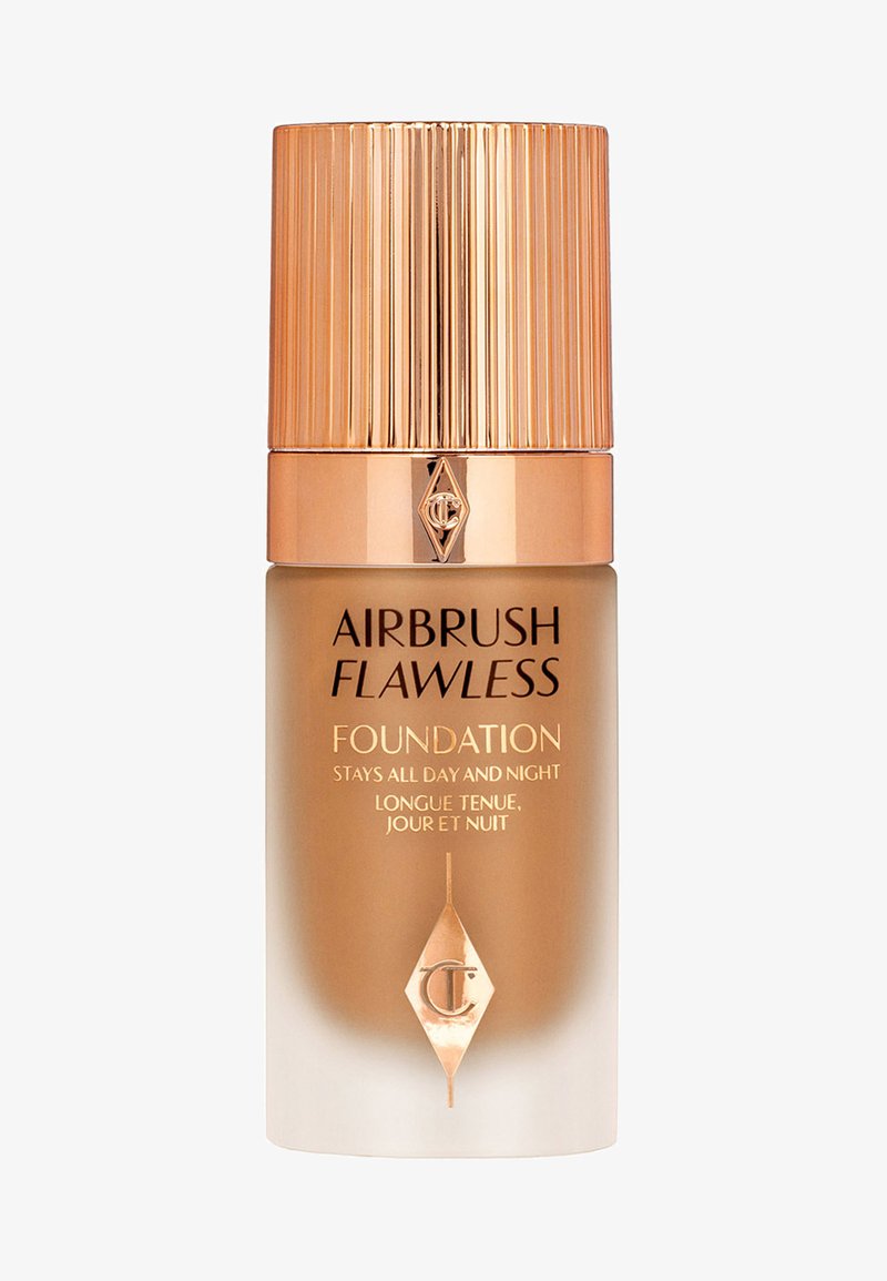 Airbrush Flawless Foundation in a glass bottle with a gradient beige to transparent finish. Gold ribbed cap and logo on the front.