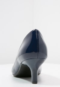 Chaussure à talon aiguille en cuir verni bleu marine avec un bout pointu et une silhouette élégante. Présente un talon mince et effilé ainsi qu'une finition lisse.