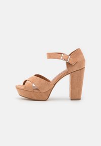 Vaaleanruskeat mokkanahkaiset korkokengät, joissa on platfrom-osa, ristikkäiset hihnat edessä ja säädettävä nilkkahihna hopeisella soljella.