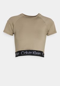 Beżowy krótki T-shirt z krótkimi rękawami, wykonany z gładkiego materiału. Posiada czarną elastyczną talię z logo "Calvin Klein" w białym kolorze.