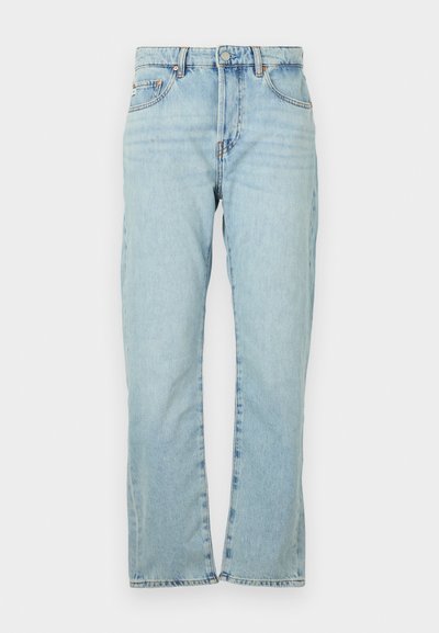 Šviesiai mėlyni džinsai su tiesiais kelnių kirpimais. Turintys penkias kišenes, metalinį mygtuko užsegimą ir šiek tiek nusitrynusią tekstūrą.