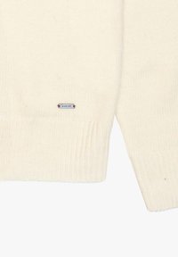 Pullover a maglia di colore crema con polsini e orlo a coste. Etichetta di branding ben visibile cucita vicino al bordo inferiore. Tessuto morbido, vestibilità rilassata.
