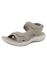 Grå mockaskinn sandal med justerbara kardborreband, öppen tå-design och en dämpad vit sula. Har dekorativ sömnad och utskärningar.