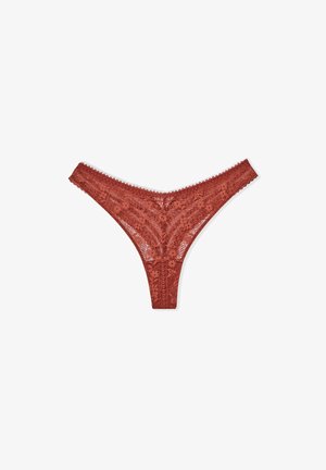 Kantstring in roestig rood, met bloemenpatronen, golvende rand en een laag uitgesneden ontwerp. Transparant materiaal versterkt de textuur.