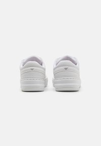 Hvite sneakers med en glatt skinnfinish, med rund form, polstret ankelkrage og teksturert gummisåle.