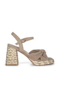 Sandale à talons hauts en daim beige avec un devant noué et un talon compensé tissé et texturé. La sangle de cheville réglable est dotée d'une boucle en argent.