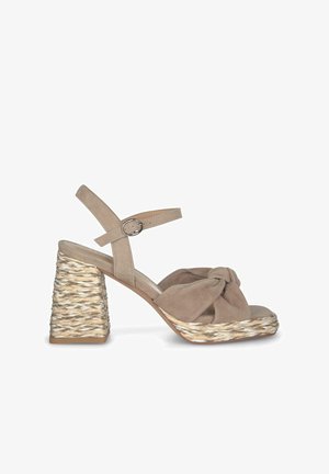 Beige suède hoge hak sandaal met een geknoopte voorkant en een geweven, textuur wedge hak. Verstelbaar enkelbandje met een zilveren gesp.