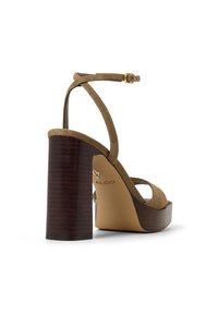Olivgrønn semsket skinn høyhælte sandaler med en bred brun hel med trestrukturen, justerbar ankelreim og åpen tå-design. ALDO-merkevaren er fremhevet.