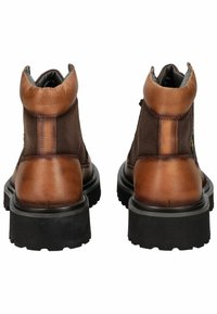 Bottines en cuir marron avec des accents en tissu texturé, bout arrondi, col rembourré et semelle en caoutchouc noir épaisse.