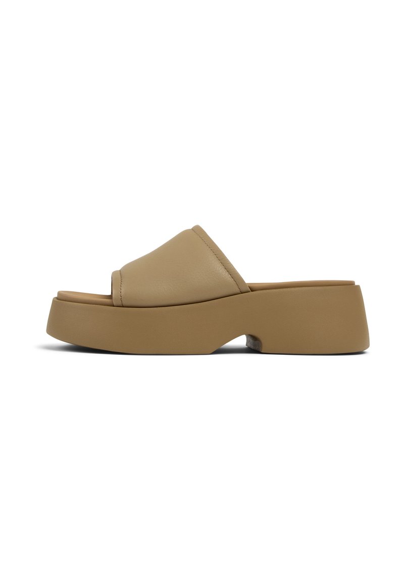 Infradito in finta pelle color tan con una larga fascia, punta aperta arrotondata e una suola piatta chunky e texturizzata. Finitura liscia con cuciture sottili.