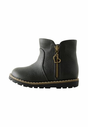 Stivale alla caviglia in finta pelle nera con una texture liscia, zip laterale in ottone, bordi cuciti e suola robusta.