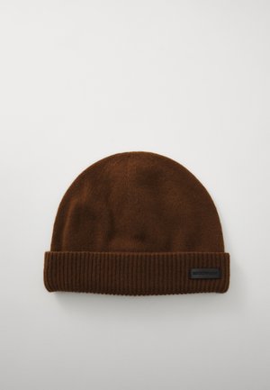Bonnet en tricot marron avec une texture douce, présentant un revers côtelé et une petite étiquette de logo noire. Dessus arrondi avec un design sans couture.