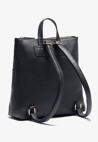 Black leather backpack with dual handles and adjustable straps, featuring a sleek design, smooth texture, and gold-tone hardware accents.